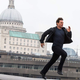 Tom Cruise running in front of a European city backdrop in a Mission: Impossible movie.